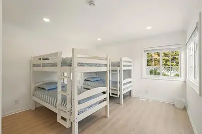 a white room with three bunk beds in it at Shores Luxury! Private Hot Tub, Fire Pit, Steps to Beach & Village Life in San Diego