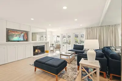 a living room with a couch and a fireplace at Shores Luxury! Private Hot Tub, Fire Pit, Steps to Beach & Village Life in San Diego