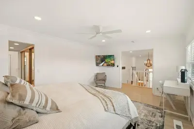 a white bedroom with a bed and a ceiling fan at Shores Luxury! Private Hot Tub, Fire Pit, Steps to Beach & Village Life in San Diego