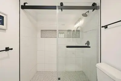 a shower with a glass door in a bathroom at Shores Luxury! Private Hot Tub, Fire Pit, Steps to Beach & Village Life in San Diego