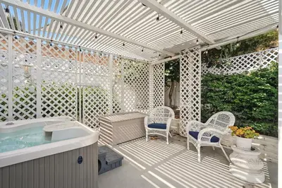 a patio with a hot tub and chairs and a pergola at Shores Luxury! Private Hot Tub, Fire Pit, Steps to Beach & Village Life in San Diego