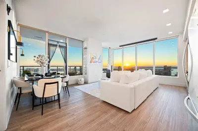 a living room with a white couch and a table at Penthouse High-Rise Ocean & City Views in San Diego