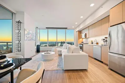 a kitchen and living room with a large window at Penthouse High-Rise Ocean & City Views in San Diego