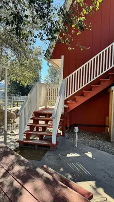 a red building with a staircase next to a fire hydrant at Julian Barn-Partment in Santa Ysabel