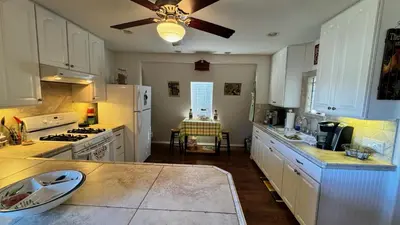 a kitchen with white cabinets and a ceiling fan at Julian Barn-Partment in Santa Ysabel