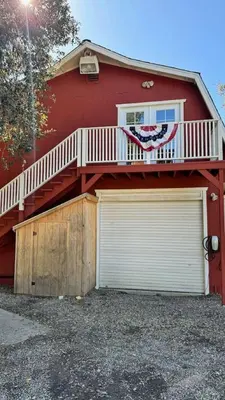 a red house with a deck and a garage at Julian Barn-Partment in Santa Ysabel