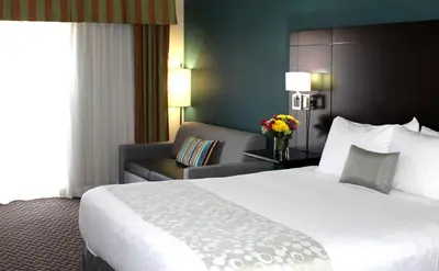 a hotel room with a large bed and a chair at Best Western PLUS La Mesa San Diego in La Mesa