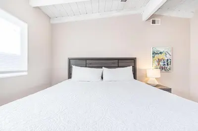 a white bedroom with a bed and a window at Pet-Friendly 3Br W Oceanview Balcony, Only Steps To Sand By Beachview Rentals in Newport Beach