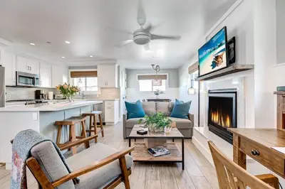 a kitchen and living room with a couch and a fireplace at Luxury 1Br Retreat W High-End Interior - Steps From Beach By Beachview Rentals in Newport Beach