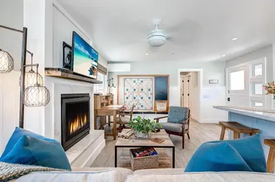 a living room with a couch and a fireplace at Luxury 1Br Retreat W High-End Interior - Steps From Beach By Beachview Rentals in Newport Beach