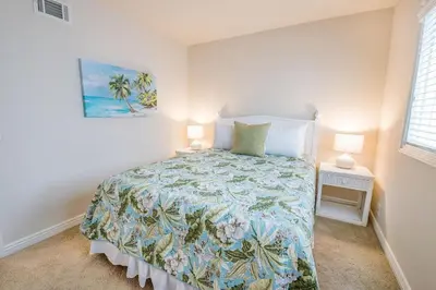 a bedroom with a bed with a blue and green bedspread at Spacious 3Br W Oceanview Patio, Steps To 35Th St Beach By Beachview Rentals in Newport Beach