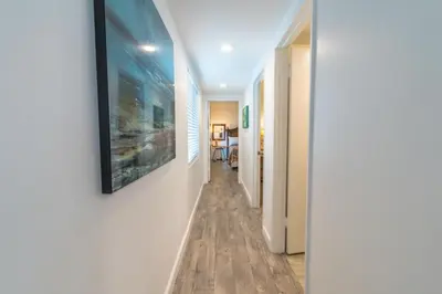 a hallway with a painting hanging on a wall at Cozy 2Br Oceanview, Half Block To Popular 29Th St Beach By Beachview Rentals in Newport Beach
