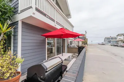 a red umbrella sitting on the side of a building at Cozy 2Br Oceanview, Half Block To Popular 29Th St Beach By Beachview Rentals in Newport Beach