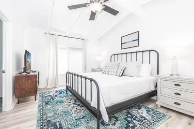 a bedroom with a bed and a ceiling fan at Remodeled 4Br Duplex, Steps From Beach And Boardwalk By Beachview Rentals in Newport Beach