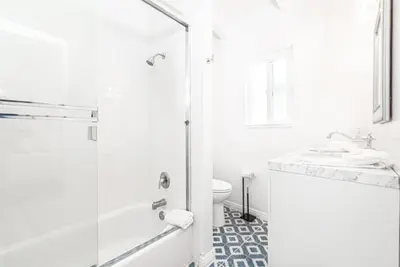 a white bathroom with a shower and a toilet at Remodeled 4Br Duplex, Steps From Beach And Boardwalk By Beachview Rentals in Newport Beach