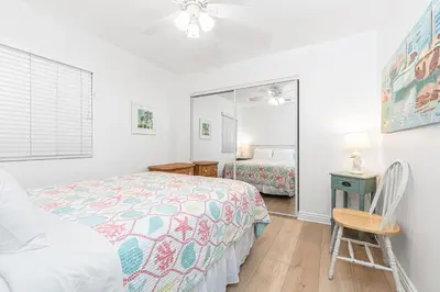 a bedroom with a bed and a chair and a mirror at Spacious 4Br W Oceanview Balcony, Ac, Near 40Th St Beach By Beachview Rentals in Newport Beach