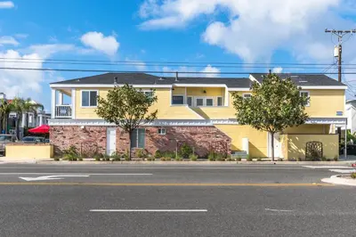 a yellow house on the side of a street at Spacious 4Br W Oceanview Balcony, Ac, Near 40Th St Beach By Beachview Rentals in Newport Beach
