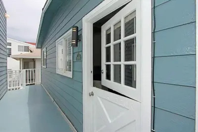 a blue house with a white door and a porch at Cozy 2Br W Ac And Private Patio, Steps To 40Th St Beach By Beachview Rentals in Newport Beach
