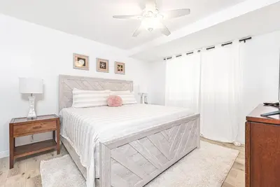 a white bedroom with a bed and a ceiling fan at Renovated 3Br W Stylish Interior Steps From 29Th St Beach By Beachview Rentals in Newport Beach