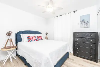 a white bedroom with a bed and a dresser at Renovated 3Br W Stylish Interior Steps From 29Th St Beach By Beachview Rentals in Newport Beach