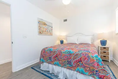 a bedroom with a bed with a colorful blanket at Updated 2Br W Ac, Huge Patio, And Grill, One Block To Sand By Beachview Rentals in Newport Beach