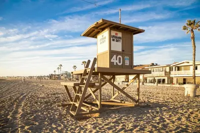 a lifeguard tower sitting on the beach at Updated 2Br W Ac, Huge Patio, And Grill, One Block To Sand By Beachview Rentals in Newport Beach