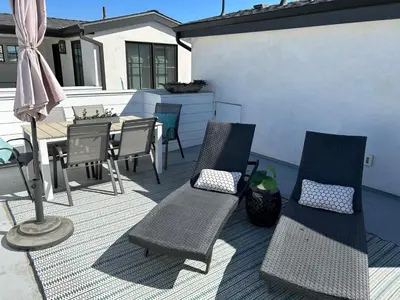a patio with two chairs and a table and a table and chairs at High-End Balboa Peninsula Home W Ac And Ocean Views By Beachview Rentals in Newport Beach