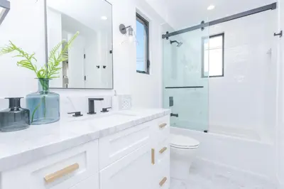 a white bathroom with a sink and a shower at High-End Balboa Peninsula Home W Ac And Ocean Views By Beachview Rentals in Newport Beach