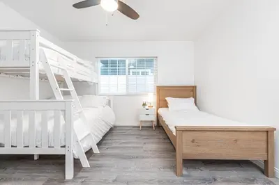 a white bedroom with a bunk bed and a ladder at Modern 2Br W Oceanview Patio, Half Block To 29Th St Beach By Beachview Rentals in Newport Beach