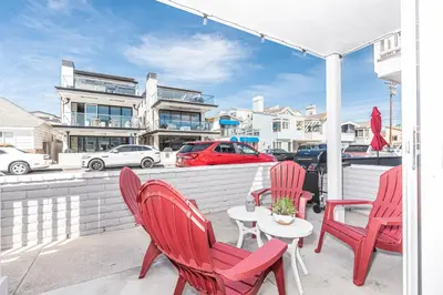 a group of red chairs and a table on a patio at Modern 2Br W Oceanview Patio, Half Block To 29Th St Beach By Beachview Rentals in Newport Beach