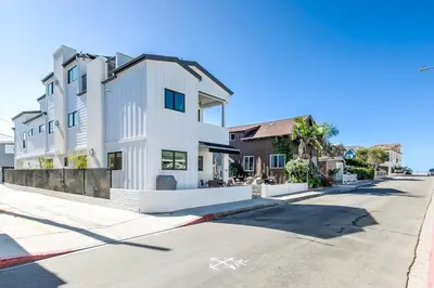 a white building on the side of a street at 3Br Luxury Condo W Rooftop Deck, Fire Pit, Steps To Sand By Beachview Rentals in Newport Beach