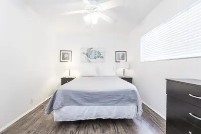 a white bedroom with a bed and a ceiling fan at Pet-Friendly 3Br W Ac, Oceanview Patio, Steps From Beach By Beachview Rentals in Newport Beach