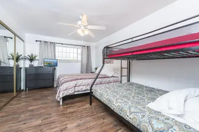 a bedroom with two bunk beds and a ceiling fan at Pet-Friendly 3Br W Ac, Oceanview Patio, Steps From Beach By Beachview Rentals in Newport Beach