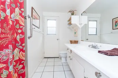 a bathroom with a white sink and a red shower curtain at Pet-Friendly 3Br W Ac, Oceanview Patio, Steps From Beach By Beachview Rentals in Newport Beach