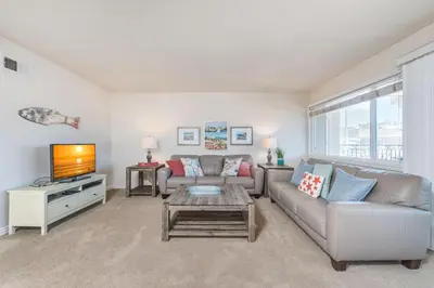 a living room with a couch and a tv at Spacious 4Br W Oceanview Balcony, 3 Houses From The Beach By Beachview Rentals in Newport Beach
