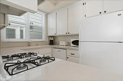 a white kitchen with a stove and a white refrigerator at 3Br Oceanview W Prime Peninsula Location Near Beach By Beachview Rentals in Newport Beach