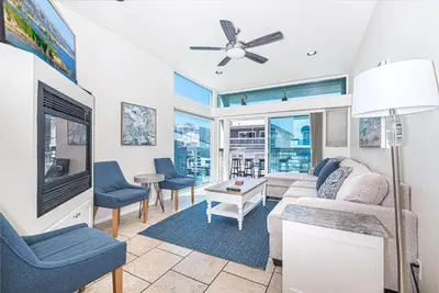 a living room with a couch and a tv at Modern Oceanview Tri-Level Steps From 43Rd St Beach By Beachview Rentals in Newport Beach