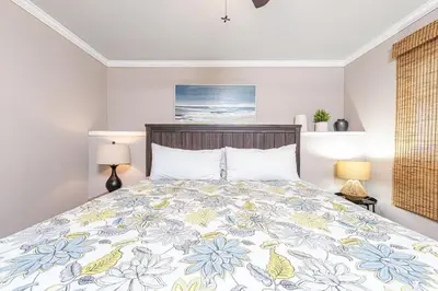 a bedroom with a bed with a floral bedspread at Pet-Friendly 3Br Retreat W Large Patio Steps From Beach By Beachview Rentals in Newport Beach