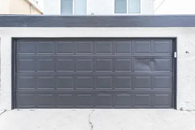 a black garage door on the side of a building at Pet-Friendly 3Br Retreat W Large Patio Steps From Beach By Beachview Rentals in Newport Beach