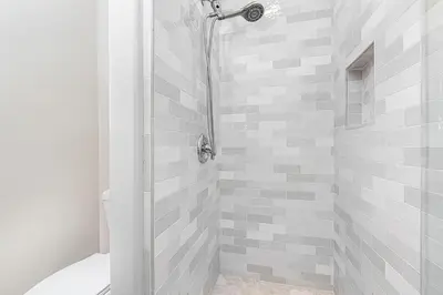 a bathroom with a shower with gray and white tiles at Pet-Friendly 3Br Retreat W Large Patio Steps From Beach By Beachview Rentals in Newport Beach
