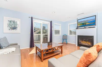 a living room with a couch and a fireplace at Family-Friendly 3Br Steps From Beach - Walk To Everything By Beachview Rentals in Newport Beach