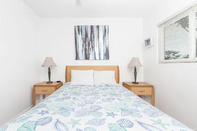 a bedroom with a bed and two night stands with two lamps at Family-Friendly 2Br Beach Home In Prime Walkable Location By Beachview Rentals in Newport Beach