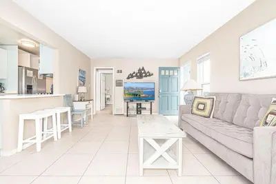 a living room with a couch and a kitchen at Upgraded 5Br Summer Vacation Home, Steps From The Sand By Beachview Rentals in Newport Beach
