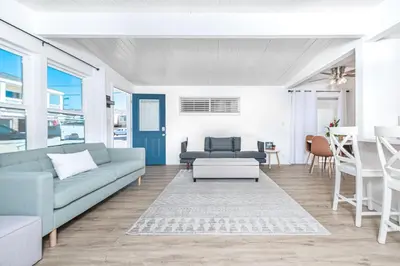 a living room with a couch and a table at Renovated 2Br W Oceanview Patio Steps From 40Th St Beach By Beachview Rentals in Newport Beach