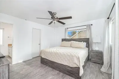 a white bedroom with a bed and a ceiling fan at Charming Oceanview 3Br Half Block To 29Th St Beach By Beachview Rentals in Newport Beach