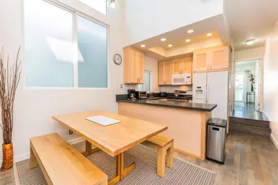 a kitchen with a wooden table and a counter top at Modern Oceanview Tri-Level Condo Steps From The Beach By Beachview Rentals in Newport Beach