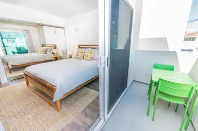 a bedroom with a bed and a table and chairs at Modern Oceanview Tri-Level Condo Steps From The Beach By Beachview Rentals in Newport Beach