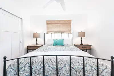 a bedroom with a bed with a blue pillow on it at Luxury 4Br Coastal Retreat W Rooftop Deck And Ocean Views By Beachview Rentals in Newport Beach