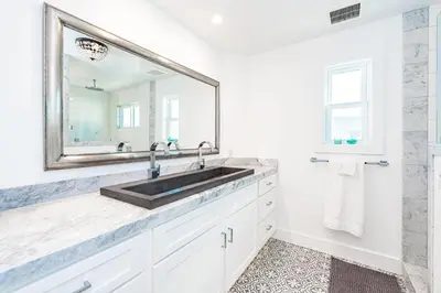 a white bathroom with a sink and a mirror at Luxury 4Br Coastal Retreat W Rooftop Deck And Ocean Views By Beachview Rentals in Newport Beach