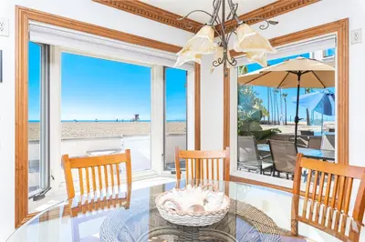 a dining room with a view of the beach at Oceanfront 2Br W Ac, Updated Interior, And Panoramic Views By Beachview Rentals in Newport Beach